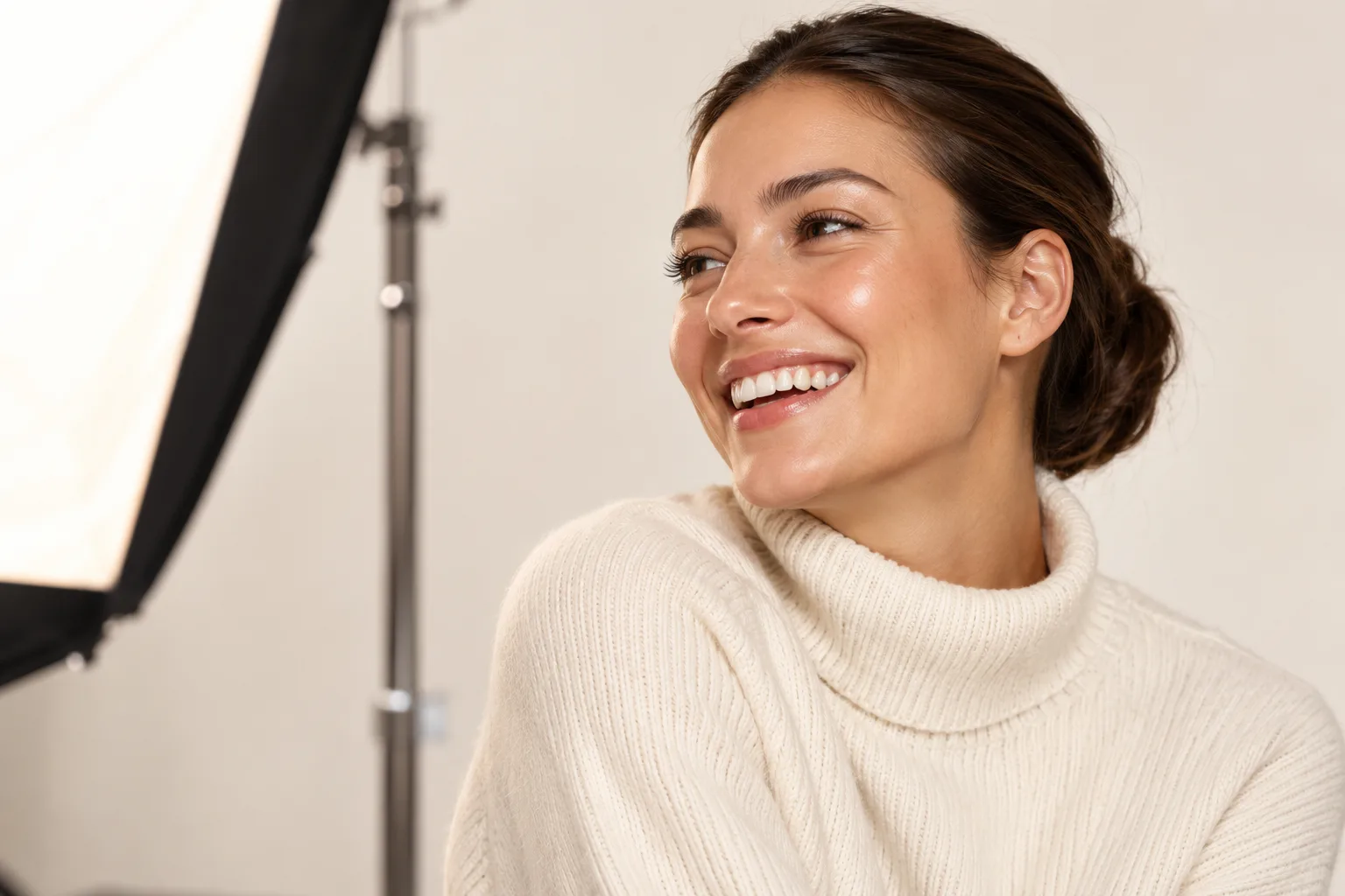 Junge Frau lacht bei einem Fotoshooting im Studio